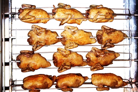 Delicious rotisserie chicken turning on a spit の写真素材