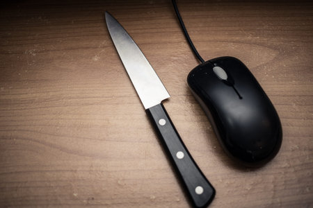 knife with mouse in dark tone,computer online or social network killer murder concept