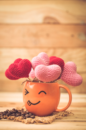 smiley funny coffee cup with heart on wood background, fun happy enjoy with love concept vintage color tone background for postcard.の写真素材