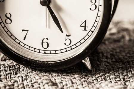 Retro vintage clock on sack closeup at 5 o'clock