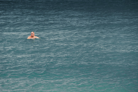 Pattaya, Thailand - MARCH 29, 2015: Older leaving swim alone at the sea, Elder Loneliness Epidemic.の写真素材