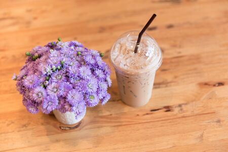 cool drink in summer day. ice coffee decoration with flower on wood table.の写真素材