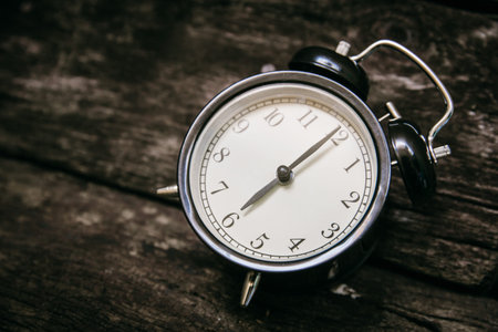 old clock retro style show 6 o'clock on wood background.
