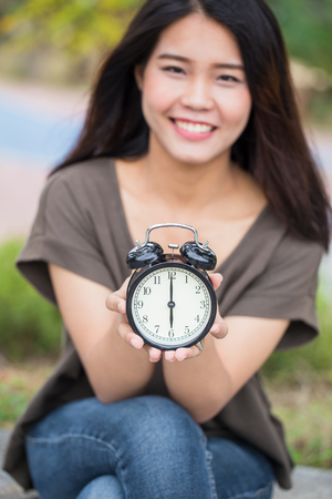 Asian women hand hold show retro clock times at 6 o'clock, It's time to do something conceptの写真素材