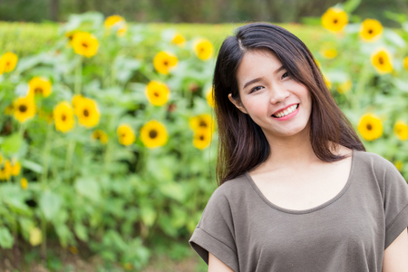 cute portrait asian Thai teen smile with sunflower with copy space.の写真素材