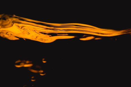 Gold Liquid Oil fluid water reflect on black background.の写真素材