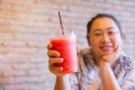 Fatty women tubby drinking fruit smoothie fruit healthy drink good for diet and cool ice for hot day in summer season.の写真素材