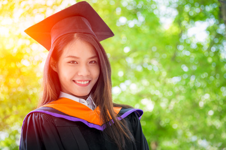 Asian cute women portrait graduation with green nature background, Thailand university.の写真素材