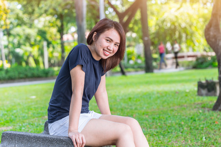 Asian healthy teen sitting  smile in the park wear casual sport outdoor clothesの写真素材