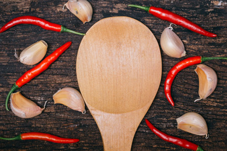 Chilli and Garlic on wood with wooden spoon space for text for Thai food menu backgroundの写真素材