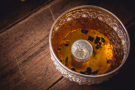 flower scent holy water in handcraft silver bowl for songkran festival and cleaning buddha statue in Thai New Yearの写真素材