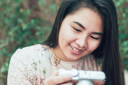 asian women enjoy with mirrorless digital camera looking her photos and smileの写真素材