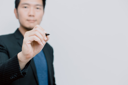 Asian business man with pen write his idea on boardの写真素材