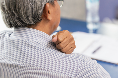 Asian Elderly back neck and shoulder pain using hand to massage and rub.の写真素材