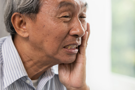 Asian Old man elder toothache pain suffer from dental problem teeth caries decayed tooth.の写真素材