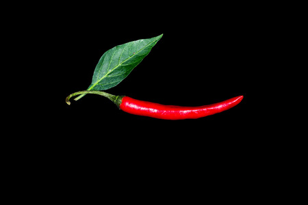 chilli pepper with leaf red vegetable isolated on black with pathの写真素材