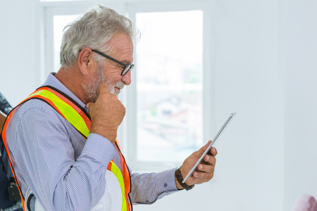 professional senior engieer usign tablet and thinking gestureの写真素材