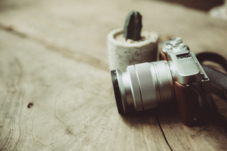 vintage retro design mirrorless digital camera still life on wood background with grain noise effectの写真素材