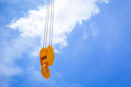 Hoist crane hook head clean new with blue sky cloud background space for text.