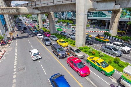 Bangkok traffic road with colorful taxi and BTS skyrail way public transport in popular travel city....