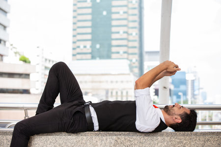 latin businessman relax lay down and play smartphone when freetime