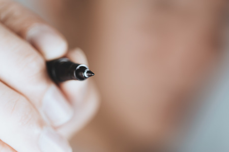 closeup hand hold pen handwriting blur background with space for text.の写真素材
