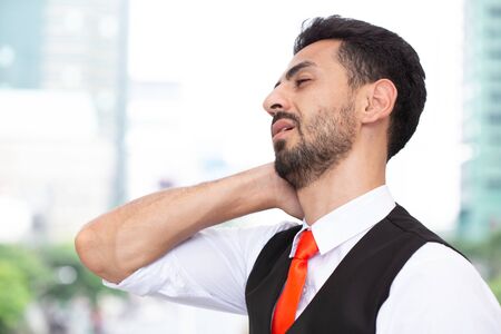 Latin Businessman neck pain, fatigue from hard work office syndromeの写真素材