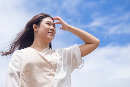 Girl teen with good healthy skin UV protection from sunny day standing happy smile with sky backgroundの写真素材