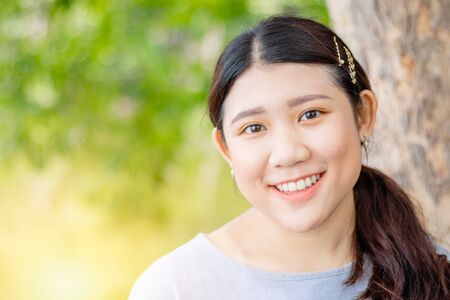 Innocent beautiful cute girl teeth smiling  portly shape healthy Asian race outdoor green nature.の写真素材