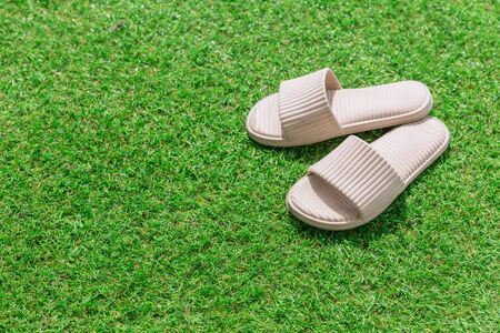 White Sandal or Slippers place on green grass with copy space for text.の写真素材