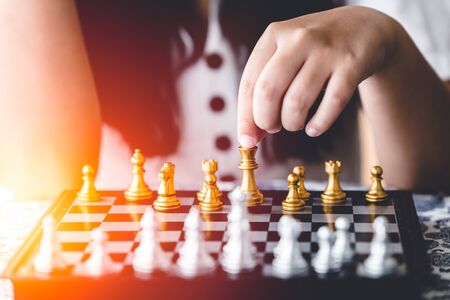 closeup girl hand playing chess board game for brain and strategy training concept.の写真素材