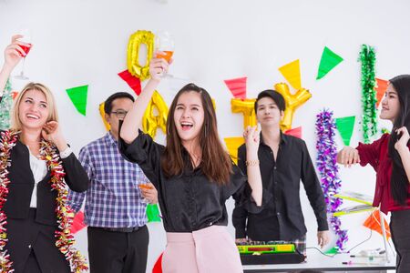 Asian businesswoman dance in office greeting new year party with staff coworker.の写真素材