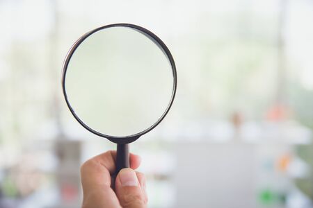 Magnifying glass with blur indoor home background.の写真素材