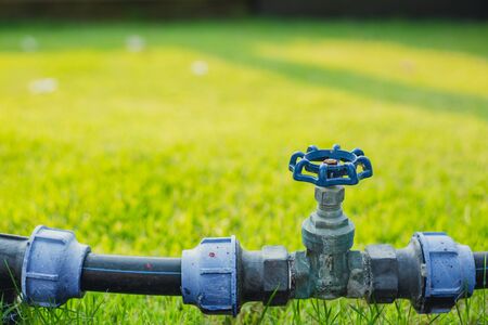 water valve pipe in the green garden grass fieldの写真素材