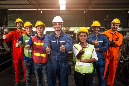 Group of Team Worker mix race  enjoy working in heavy factory standing together smiling happy hand show thumbs up wide banner.の写真素材
