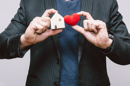 Business man handle home and red heart for Stay Home or love care people in the house family...