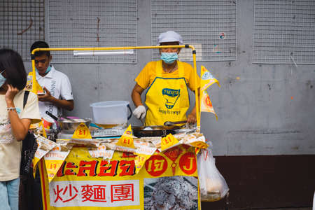 vegetarian food stall with yellow flag with symbols of eat for merit, no animal meat sign at Yaowarat J Festival Bangkok Chinatown street.18 October 2020, Bangkok,THAILAND.のeditorial素材