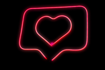 Neon light pink heart love in chat bubble box isolated grow in the dark background.