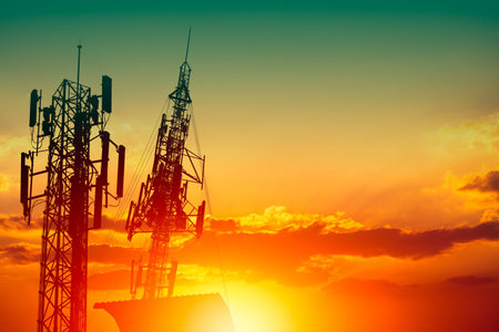 Silhouette of high frequency 5G station communication tower or 4G network telephone cellsite with...