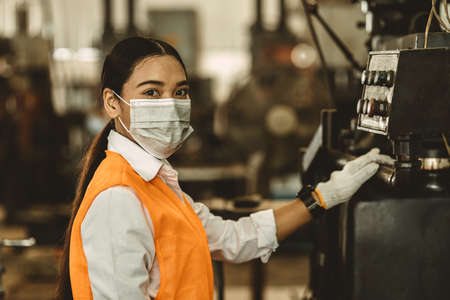 Women worker wear disposable face mask for protection Corona Virus Spreading and smoke dusty air pollution filter in factory for healthy labor care.の写真素材