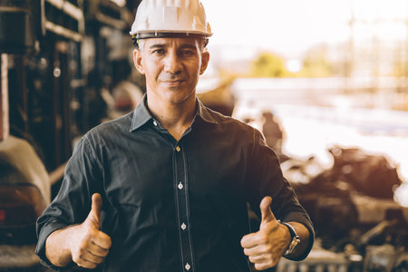 Professional adult Engineer male work in factory standing hands show two Thumbs up for good job or best working with confident smileの写真素材