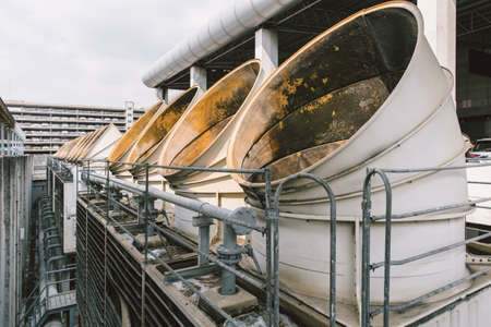 Closeup Air cooling tower for HVAC chilling tower pipe ventilator air hole units at building rooftop outdoor blue sky.の写真素材