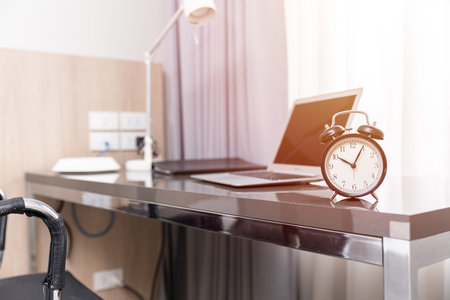 Working space at home or business desk table with alarm clock,  morning at home office hours work time concept.の写真素材