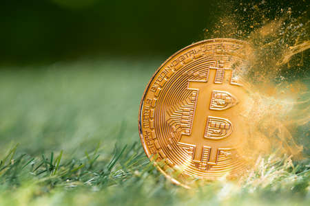 Bitcoin digital cryptocurrency losing value price fall drop breaking down concept. crypto money coin explosion dispersion fade out effect.の写真素材
