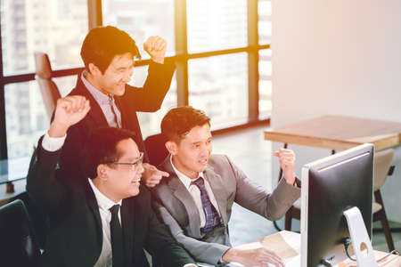 Businessman winning success teamwork watching good news from monitor computer in office, Job done finish and successful team concept.の写真素材
