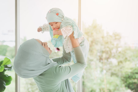 Muslim family or Islam mother with her healthy baby happiness playing together at lovely home....
