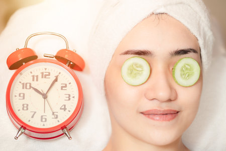 Women facial treatment in spa with time clock. Beauty times reverse to healthy skin to baby face anti aging cosmetic concept.の写真素材