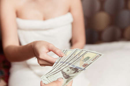 Women night worker reciving money from customer pay for personal massage service in hotel room.の写真素材