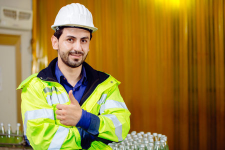 Portrait smart Latin worker in cargo port logistic warehouse standing confident thumbs up with...