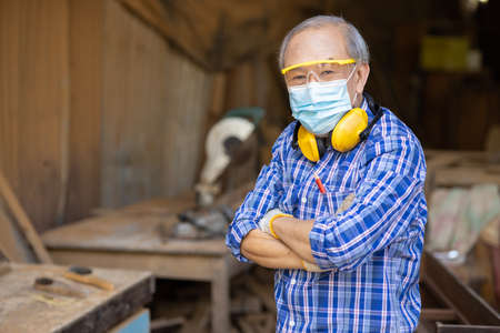 Portrait of elder wood worker hobby for good retirement, Asian male mature professional master of wood craft furniture wooden maker man.の写真素材